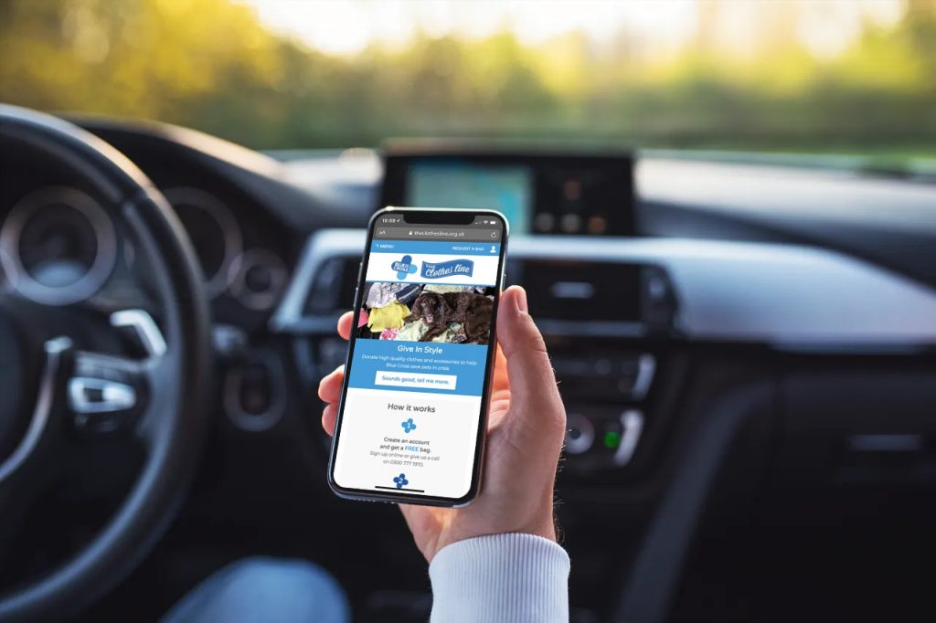 Man viewing Blue Cross on smartphone in car